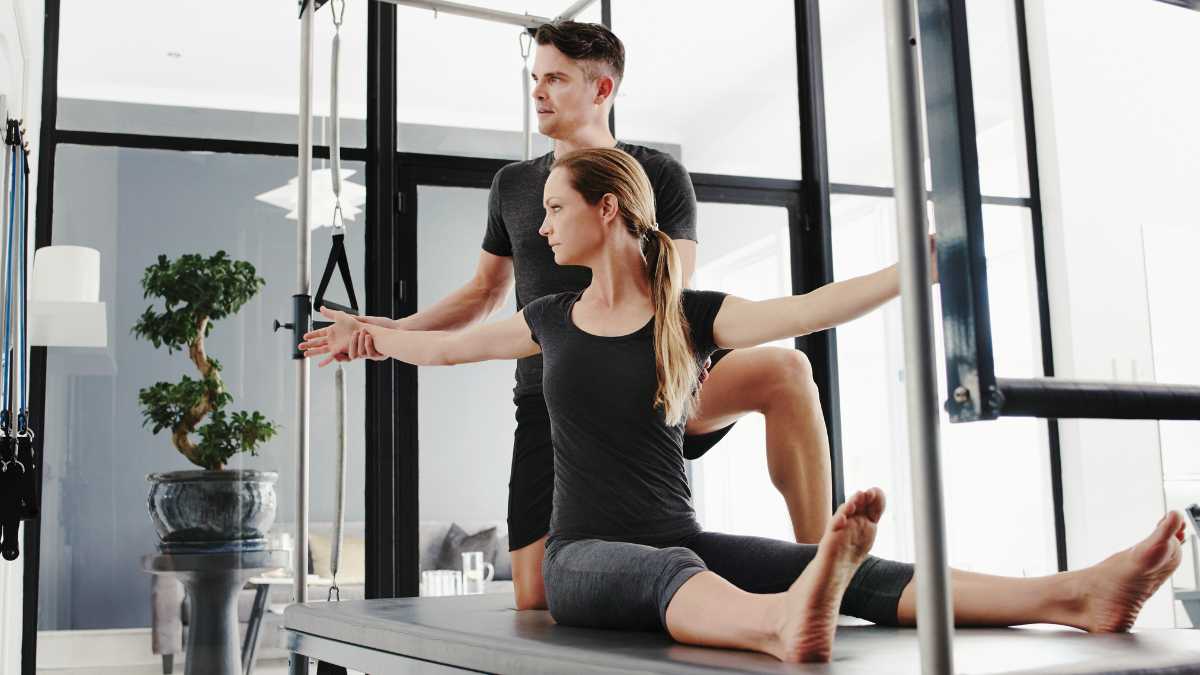 Chiropractor Guiding Woman In Stretching Exercises