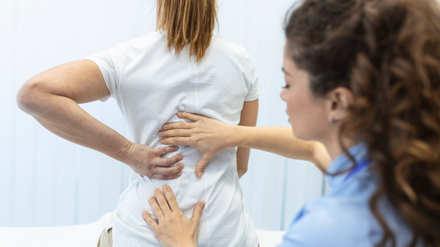 Chiropractor Assessing Patient's Back Pain