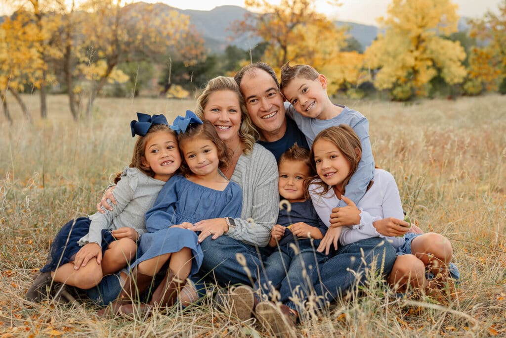 Large family of four children all snuggling and smiling for a portrait family session. Captured by Michelle Betz Photography