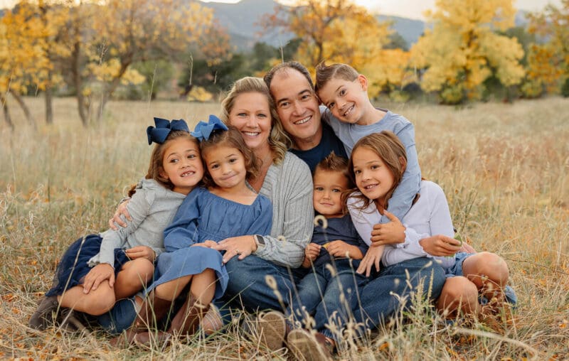 Large family of four children all snuggling and smiling for a portrait family session. Captured by Michelle Betz Photography