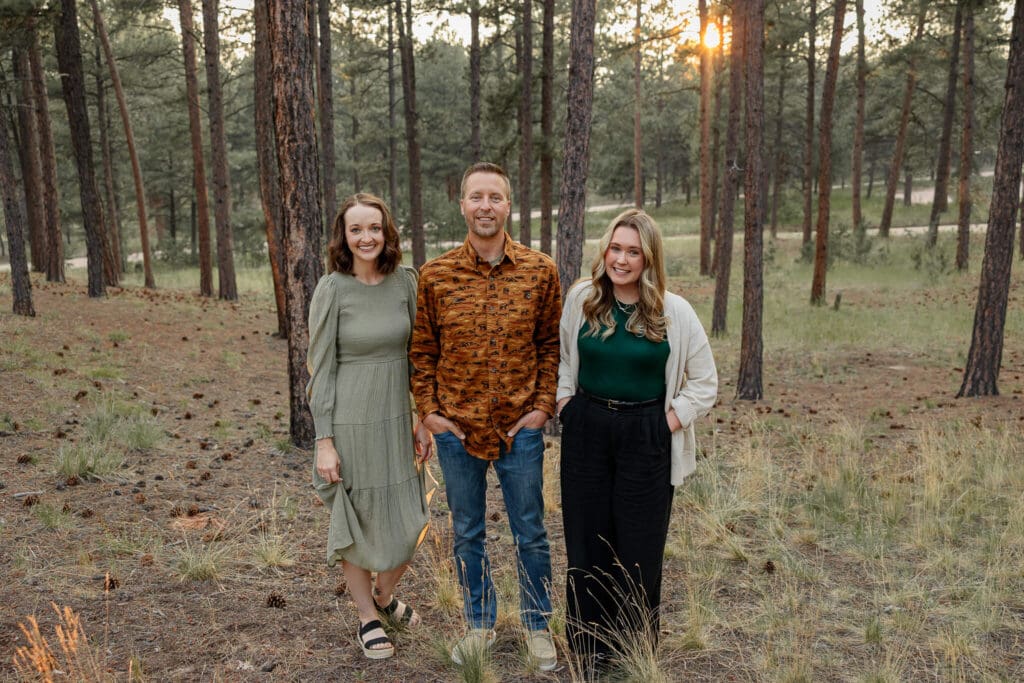 The staff at the best Colorado Springs chiropractors office. Smiling for a portrait, surrounded by forest. 