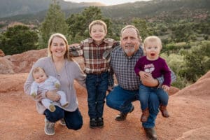 Grandparents and grandchildren smiling together for a family portrait. Surrounded by Garden of the Gods in Colorado Springs.