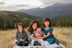 Four children, snuggling with each other on a blanket for a family portrait. Clients on Radix Chirorpactics pediatric care.